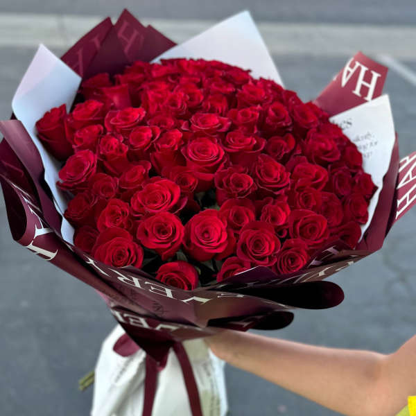Large bouquet of red roses wrapped in burgundy and white paper