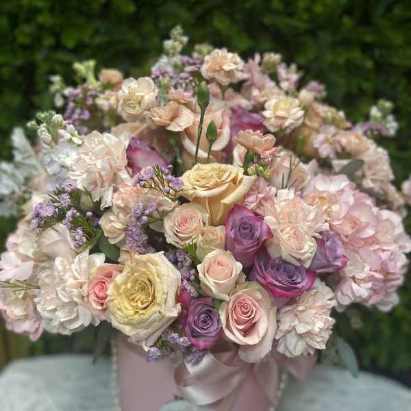 Pastel rose bouquet in a pink hatbox with ribbon