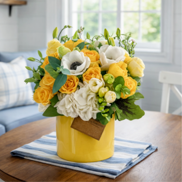 Yellow and white flower arrangement in a yellow vase