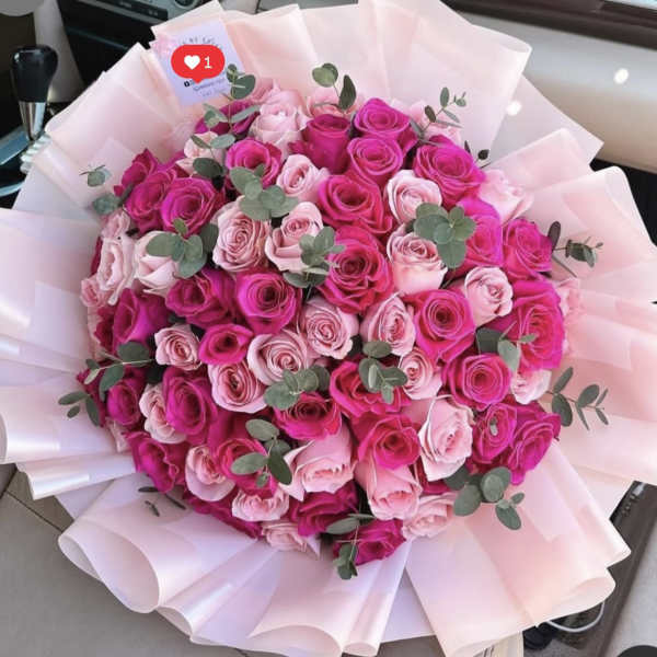 Bouquet of pink and hot pink roses wrapped in pale pink paper