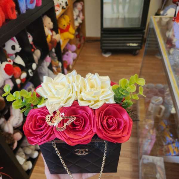 Black gift box with red and white roses and green accents