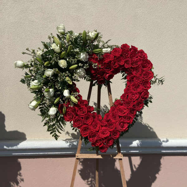 Heart-shaped red and white rose wreath on a wooden easel