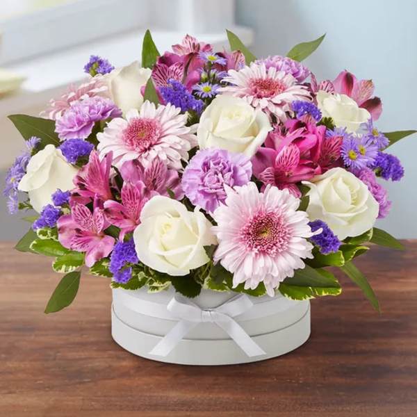 Pink and white mixed flower arrangement in a white hat box