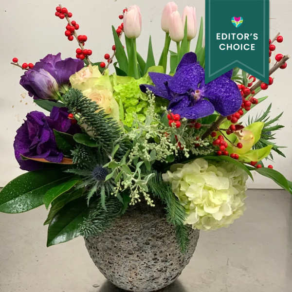Mixed floral arrangement in a textured gray vase with purple and pink blooms