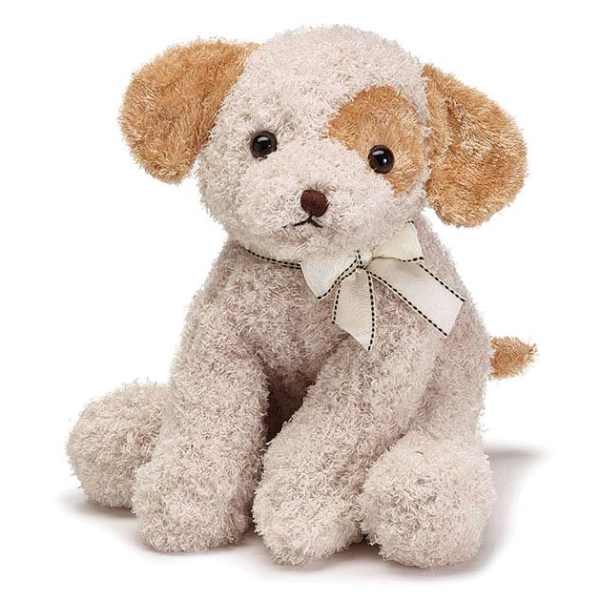 Small cream and tan plush puppy with a ribbon bow around its neck, sitting upright.