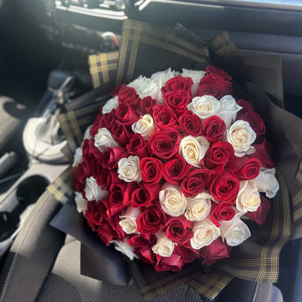 Bouquet of red and white roses wrapped in black paper