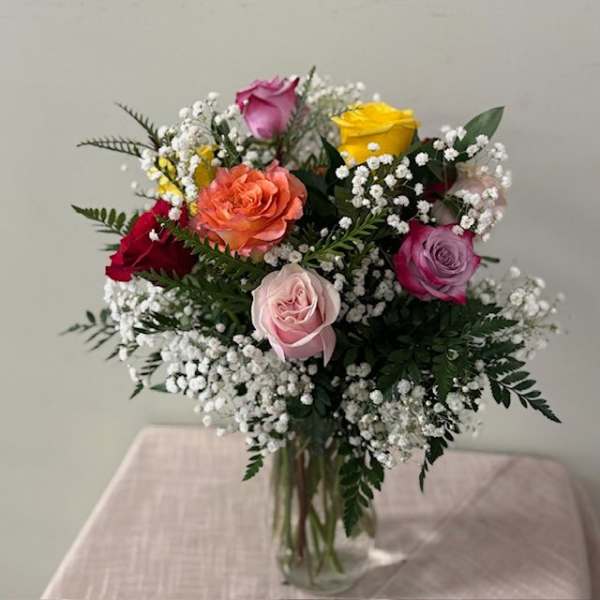 Mixed roses with baby's breath in a clear glass vase