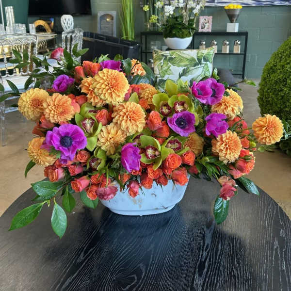 Bright mixed flower arrangement in a white bowl vase