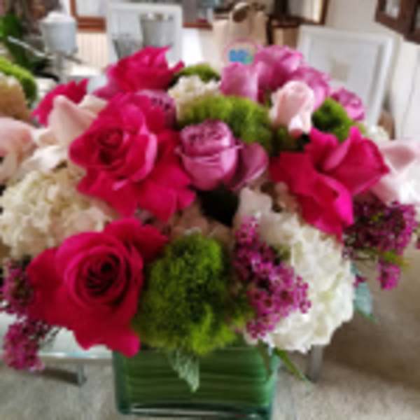 Low cube arrangement of hot pink and pale pink roses with white hydrangeas and green accents