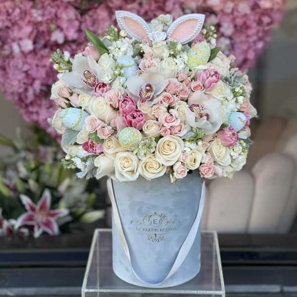 Pastel bouquet in a blue hatbox with bunny ears and decorated eggs
