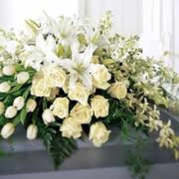 White floral casket spray with lilies and roses