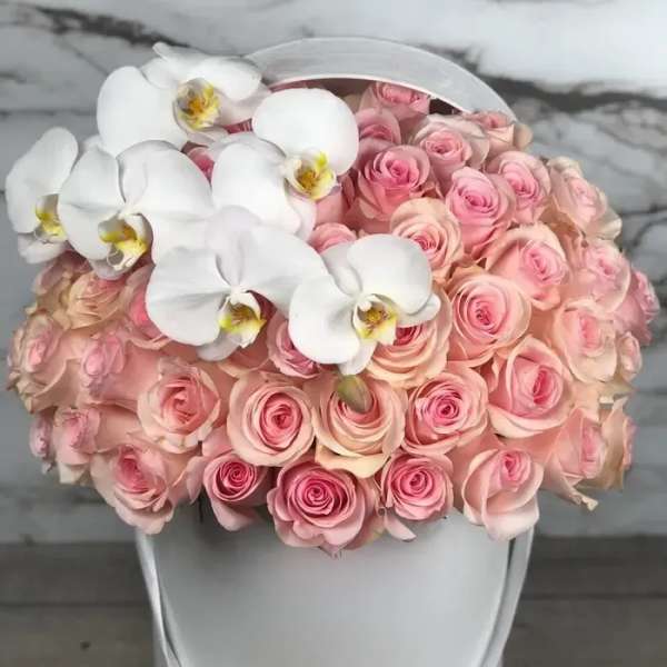Pink roses with white orchids in a white hatbox