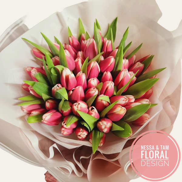Bouquet of pink tulips wrapped in pale paper