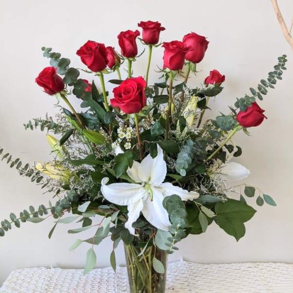 Bouquet of red roses and white lilies in a clear glass vase