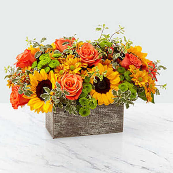 Orange roses and sunflowers arranged in a rectangular box