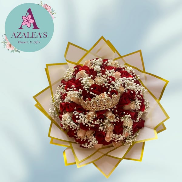 Bouquet of red and blush roses with baby's breath and a jeweled crown