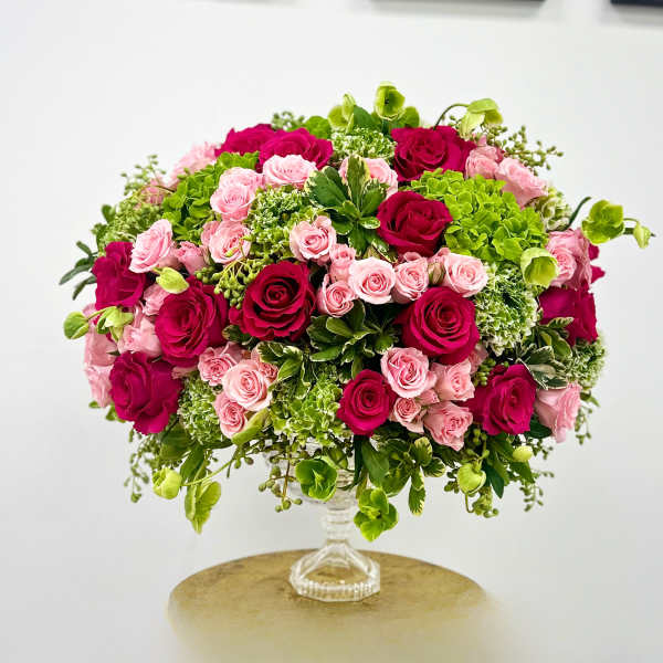 Pink and magenta roses arranged in a clear glass vase
