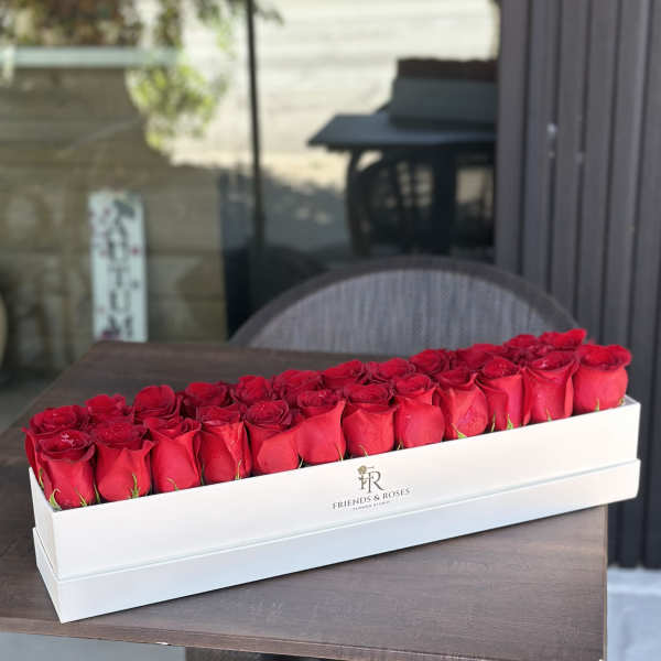 Long white box filled with red roses