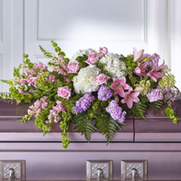 Pink and white floral casket spray with lilies and roses