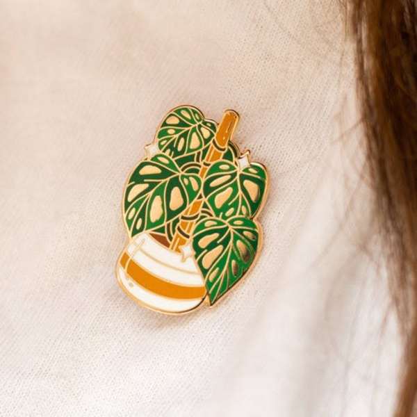 Enamel pin of a potted houseplant on white fabric