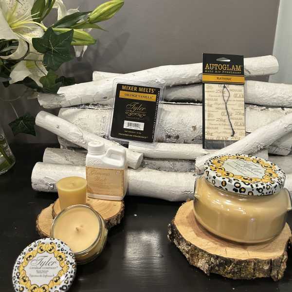 Candles and fragrance products arranged with a white lily stem