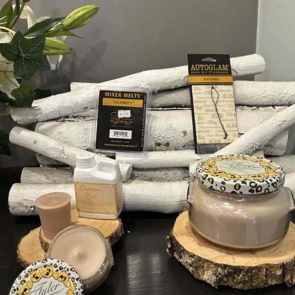 Assorted candles and fragrance products arranged on wood slices