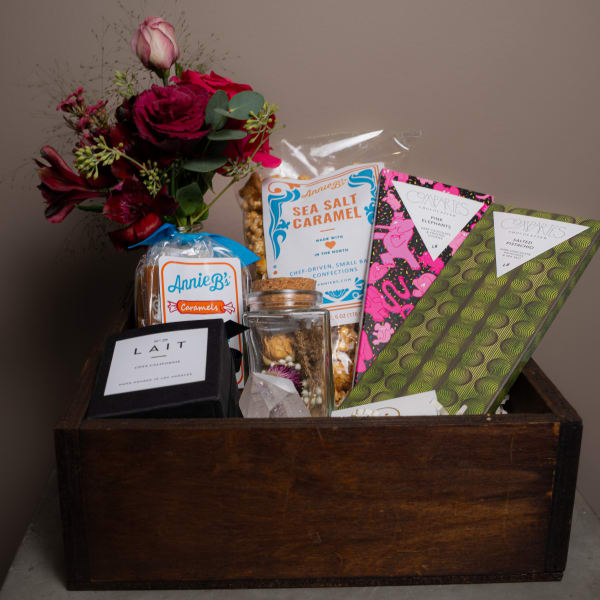 Gift basket with a burgundy flower bouquet and assorted sweets