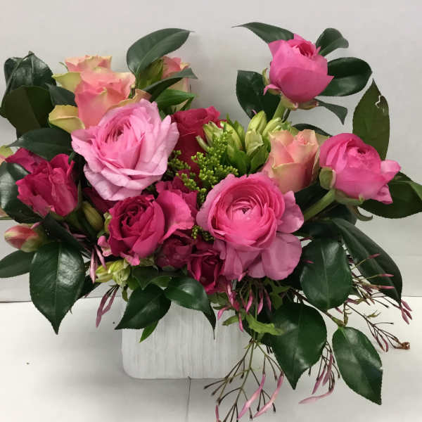Pink and peach rose bouquet in a white container