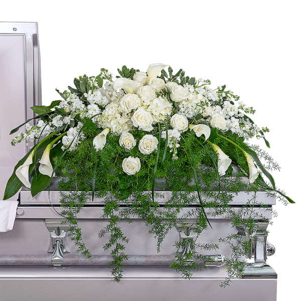 Large white floral casket spray with roses and calla lilies on a silver casket