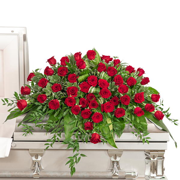 Large red rose casket spray on a light-colored casket