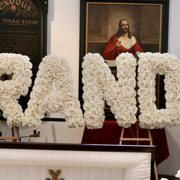 Large floral letters spelling "GRANDPA" made of white roses