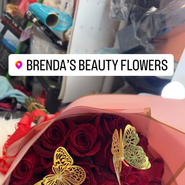 Bouquet of red roses wrapped in pink paper with gold butterfly accents