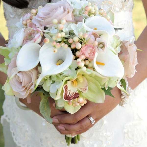 Bride holding a bouquet of white calla lilies and pale pink roses