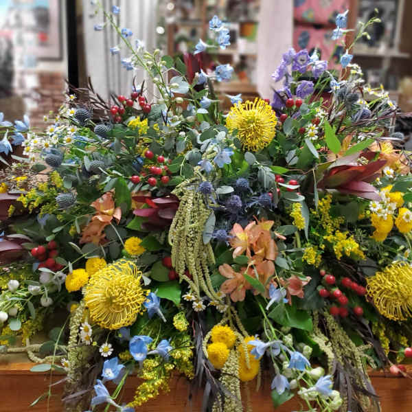 Large mixed floral arrangement with yellow, blue, and red blooms