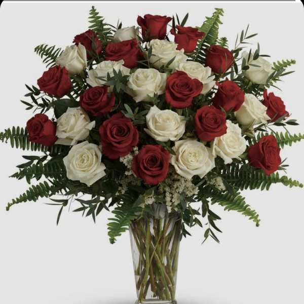 Red and white roses in a clear glass vase