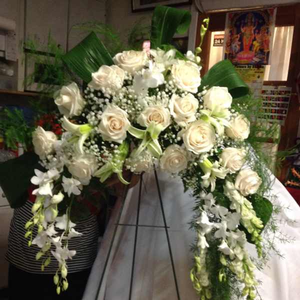 White rose funeral spray on a standing easel