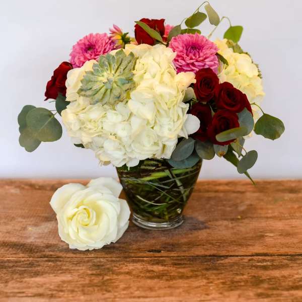 Bouquet of white hydrangeas and red roses in a glass vase