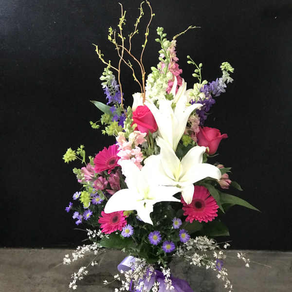Tall mixed bouquet with white lilies, pink roses, and purple flowers