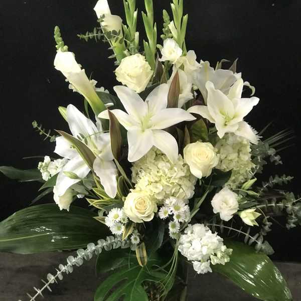White floral arrangement with lilies, roses, and hydrangeas