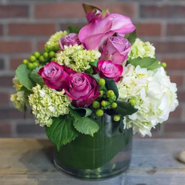 Pink roses and white hydrangeas arranged in a glass vase