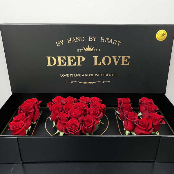 Black gift box with red roses arranged inside