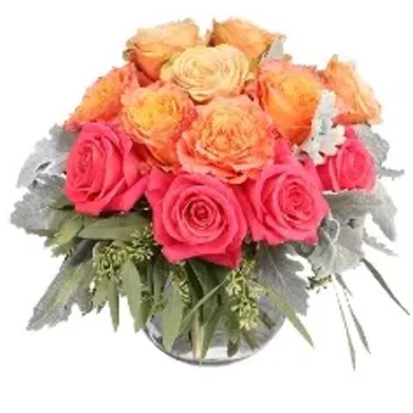 Pink and peach roses arranged in a glass vase
