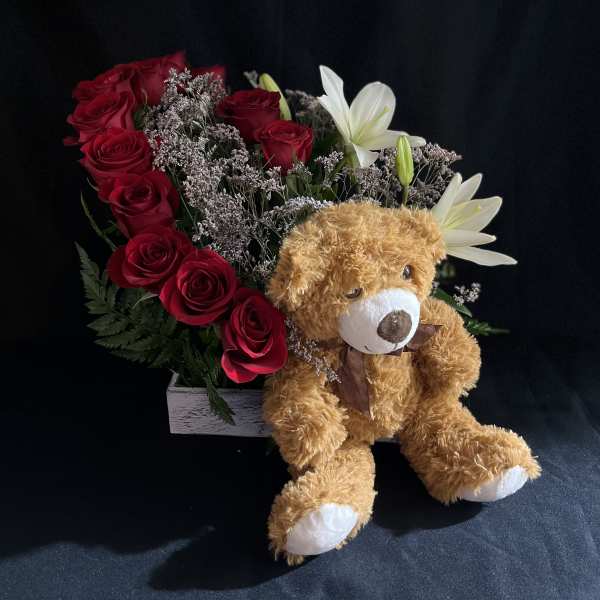 Red rose arrangement with white lilies and a teddy bear