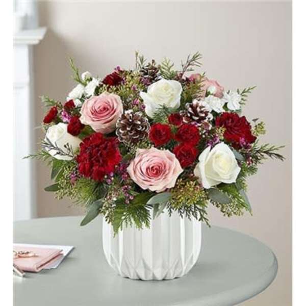 Bouquet of pink and white roses with red carnations in a white vase