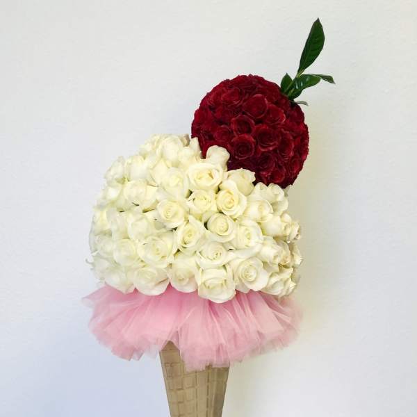 Rose bouquet arranged like an ice cream cone with pink tulle and a gold stand