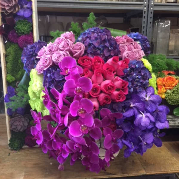 Large bouquet of pink, purple, and blue flowers with orchids and roses