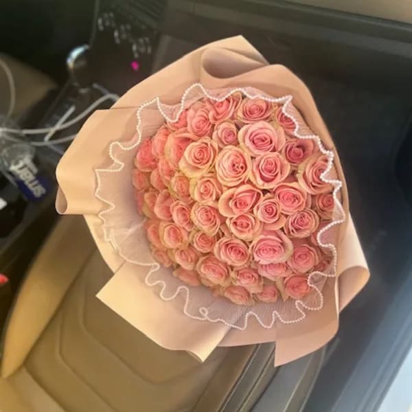 Bouquet of pink roses wrapped in pale pink paper