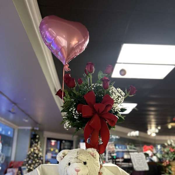 Bouquet of red roses with a pink heart balloon and teddy bear