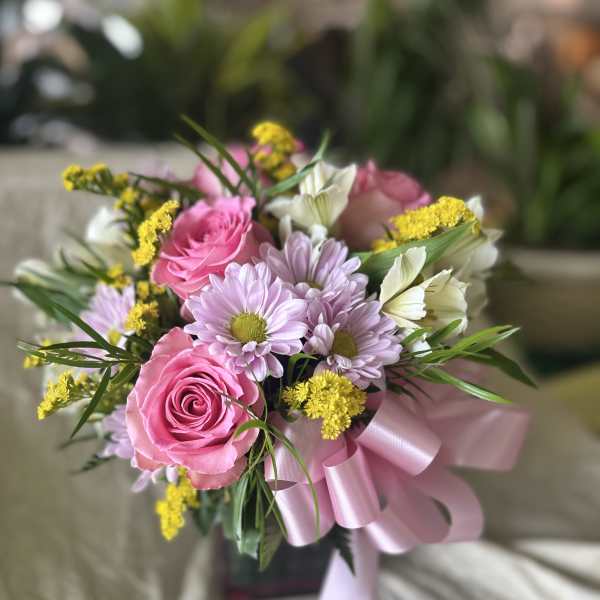 Pink roses and lavender daisies in a ribbon-tied bouquet