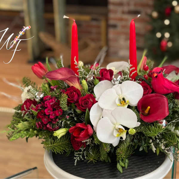 Red and white floral centerpiece with candles in a low container